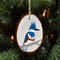 A hand-painted bird on a wood slice that is hanging on a Christmas tree at Cove Creek Photography.